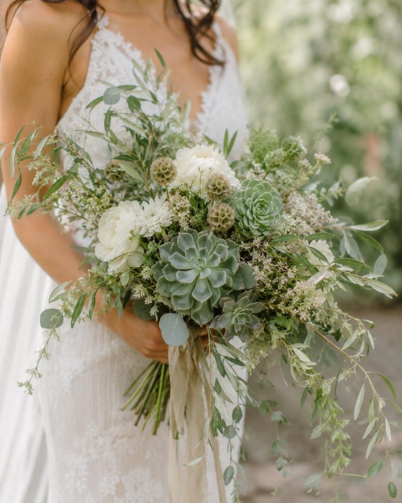 Bride holding lush succulent and greenery bouquet